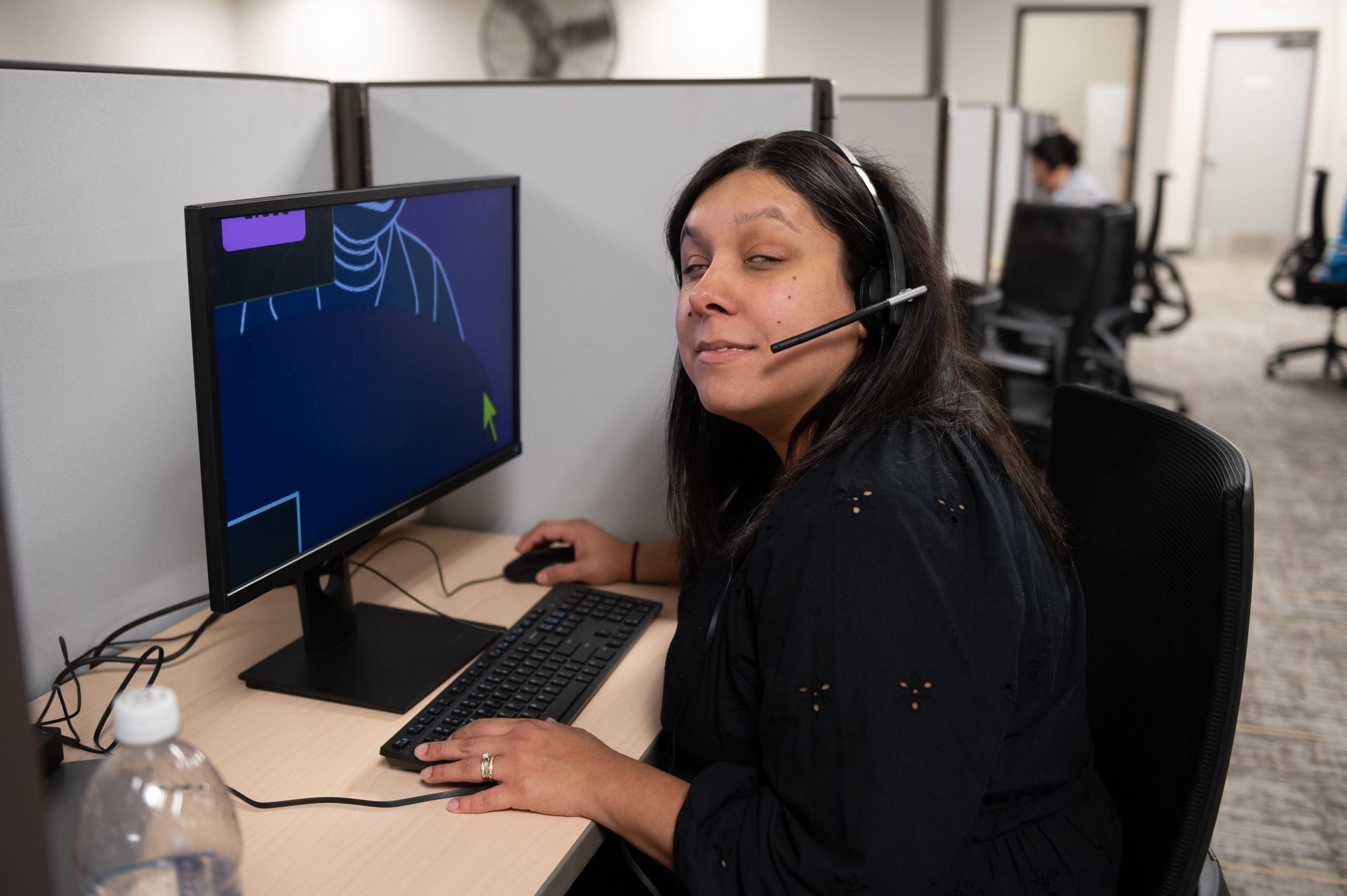 Envision contact center employee wearing a headset at her workstation